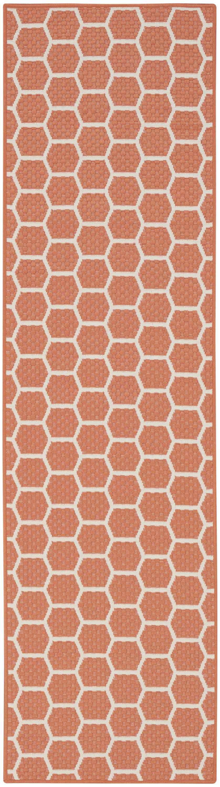 Close-up of Nourison Twist Reversible Coral Area Rug. Honeycomb pattern in coral and cream. Modern, machine-made polypropylene rug.