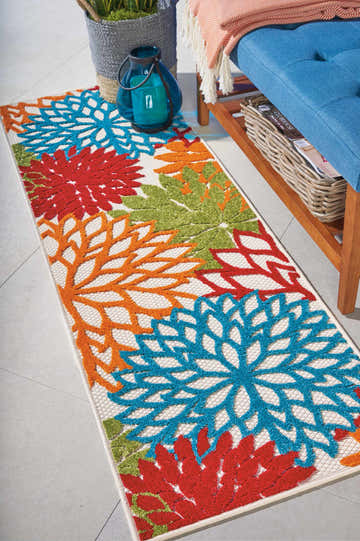Hallway scene with Nourison Aloha Green Tropical Area Rug featuring blue, orange, red, and green floral pattern.