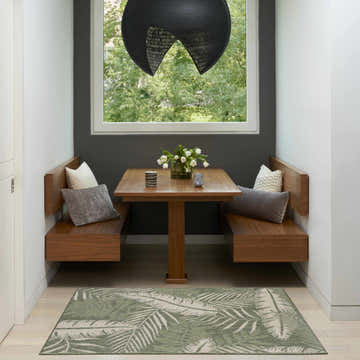 Modern dining nook with wood benches and Nourison Garden Oasis Green Ivory outdoor area rug.
