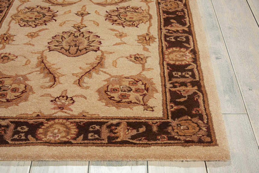 Close-up of the beige Nourison Heritage Hall Freeform Persian rug, showing floral patterns and dark brown border.