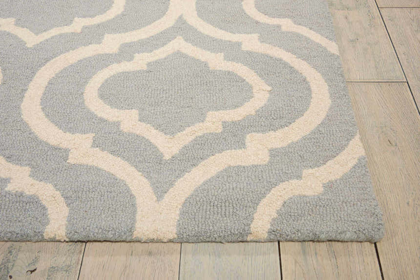 Close-up of the light blue Nourison Linear Moroccan rug, featuring a cream-colored geometric trellis pattern. Wool texture.