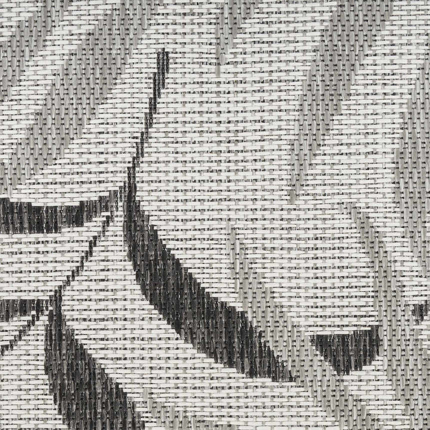 Close-up of the woven texture and grey tropical pattern on the Nourison Garden Oasis Area Rug.