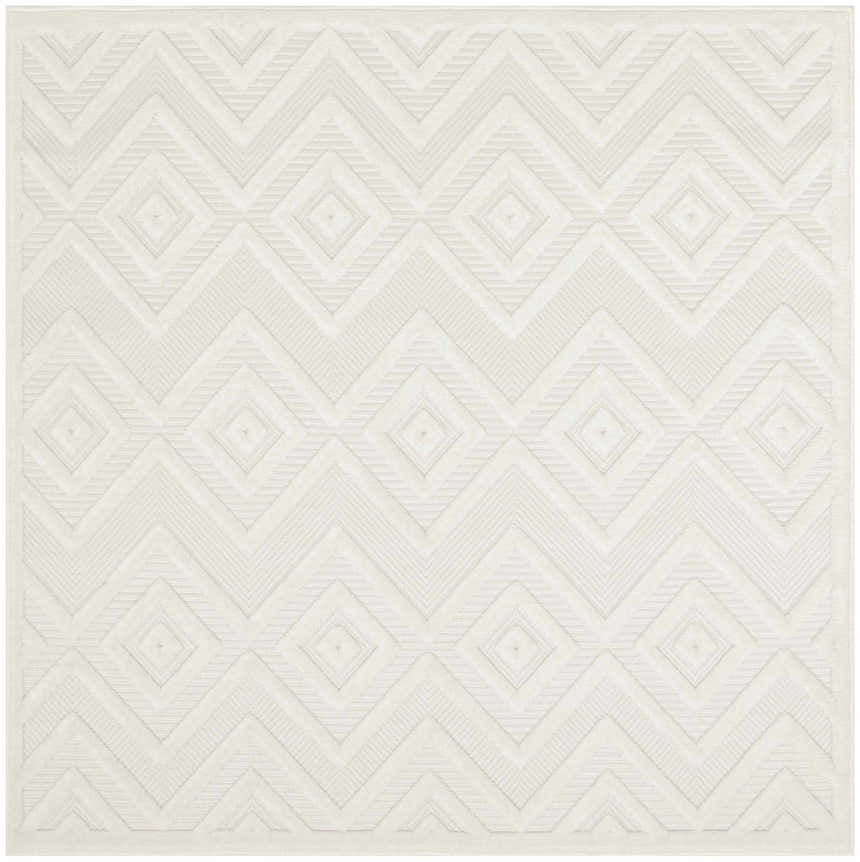 Close-up of a Nourison Versatile Ivory White rug. Features a geometric diamond and chevron pattern with subtle texture.
