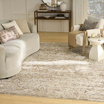 Living room scene with a beige curved sofa and Nourison Retreat Beige Vintage Area Rug.