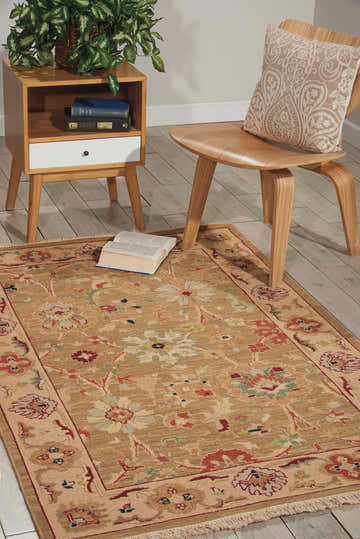 Living room scene with olive Nourison Nourmak vintage rug, wood chair and side table, and a book on the rug.