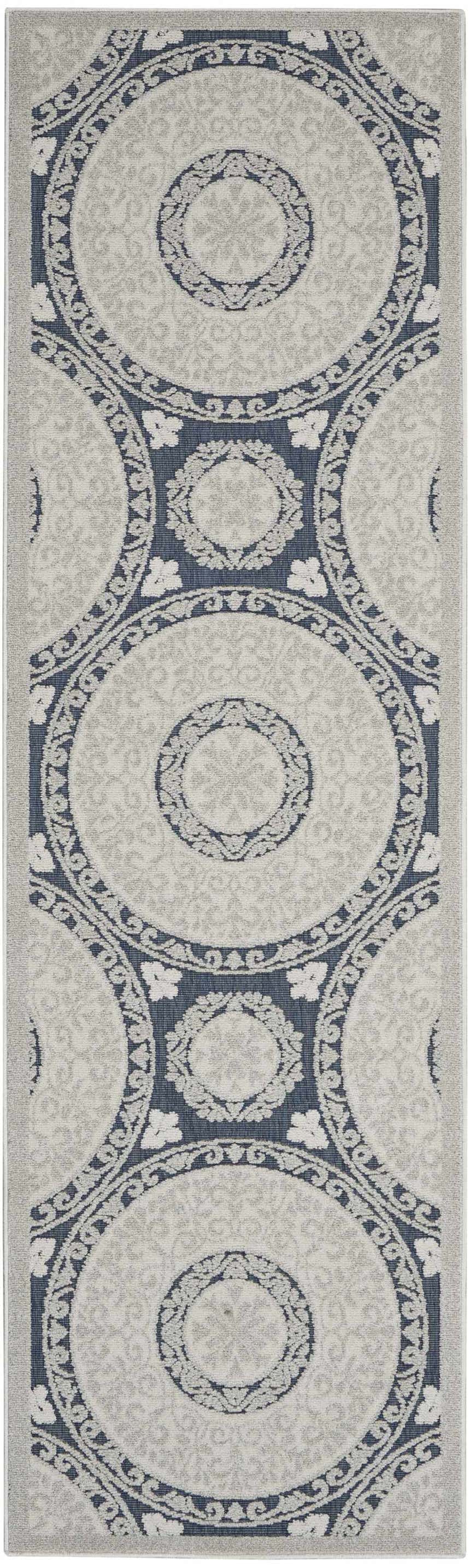 Close-up of the Nourison Key Largo Blue Contemporary Area Rug featuring a circular pattern in light blue and gray.