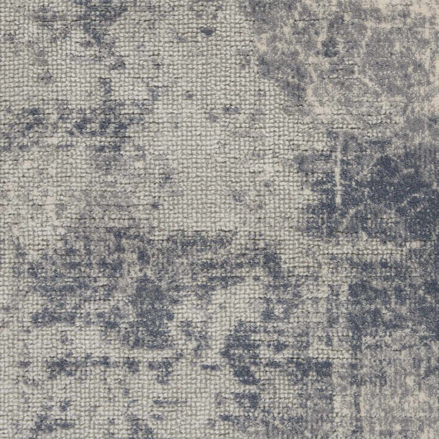 Close-up of the Nourison Rustic Textures Blue Ivory area rug, showing its textured weave and distressed pattern.