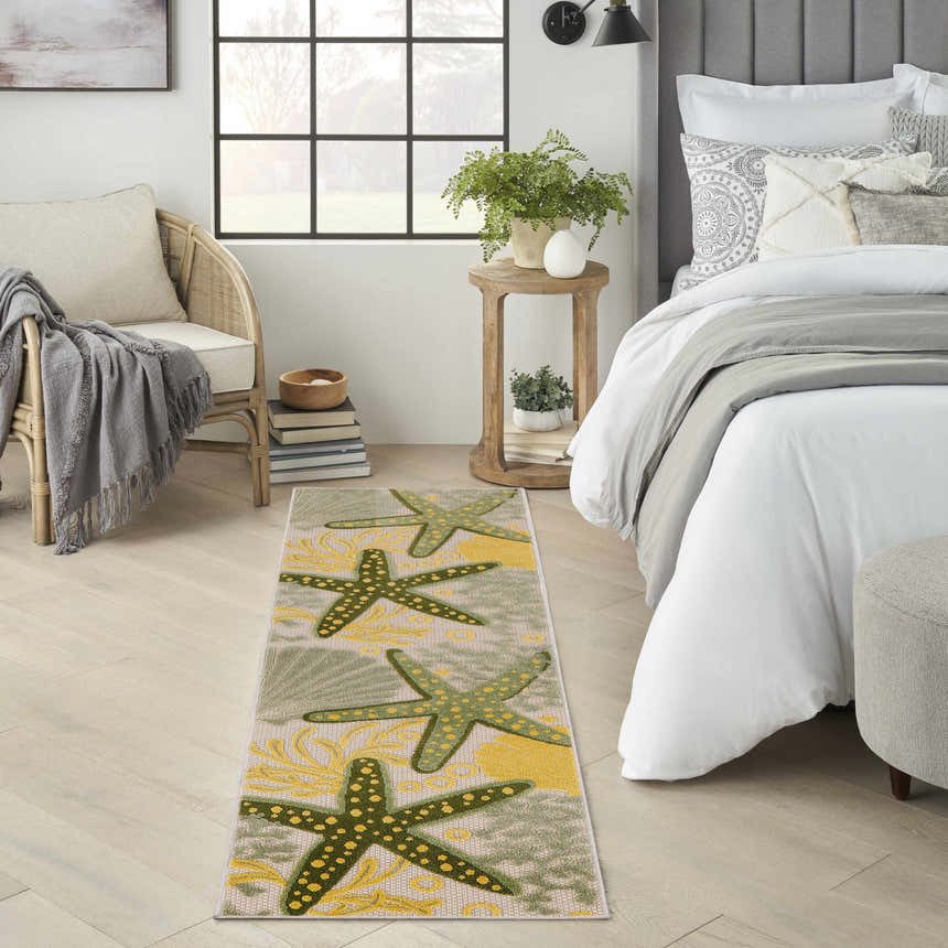 Bedroom scene with a Nourison Aloha Green Yellow runner rug featuring starfish and seashell designs.
