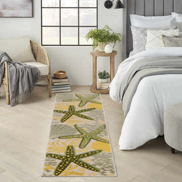 Bedroom scene with a Nourison Aloha Green Yellow runner rug featuring starfish and seashell designs.