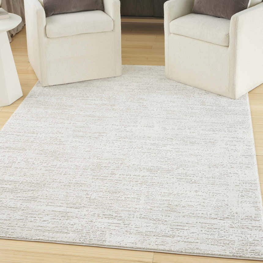 Living room scene with two chairs on Nourison Dew Ivory Beige rug.