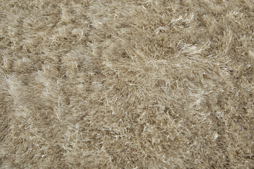 Close-up of the Feizy Indochine Modern Solid rug in tan and taupe, showing its plush, shaggy texture. Texture