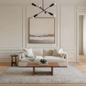 Living room scene with a Nourison Sultana Grey Blue Vintage rug, sofa, wood coffee table, and neutral decor.