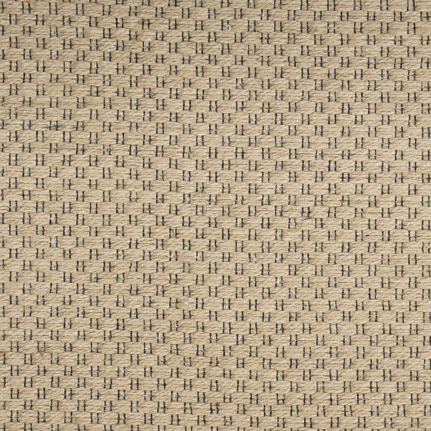 Close-up of Nourison Jute Natural rug. Woven jute texture with a small, dark geometric pattern. Mid-century modern style.
