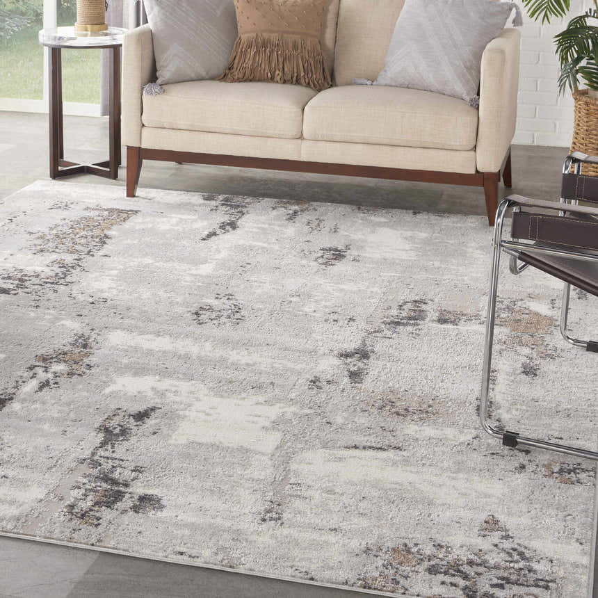 Living room scene with a Nourison Elation Grey Ivory rug, beige sofa, and modern decor.