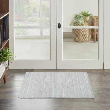 Entryway scene with a Nourison Interweave Light Blue rug, wood floors, and white french doors to a garden.