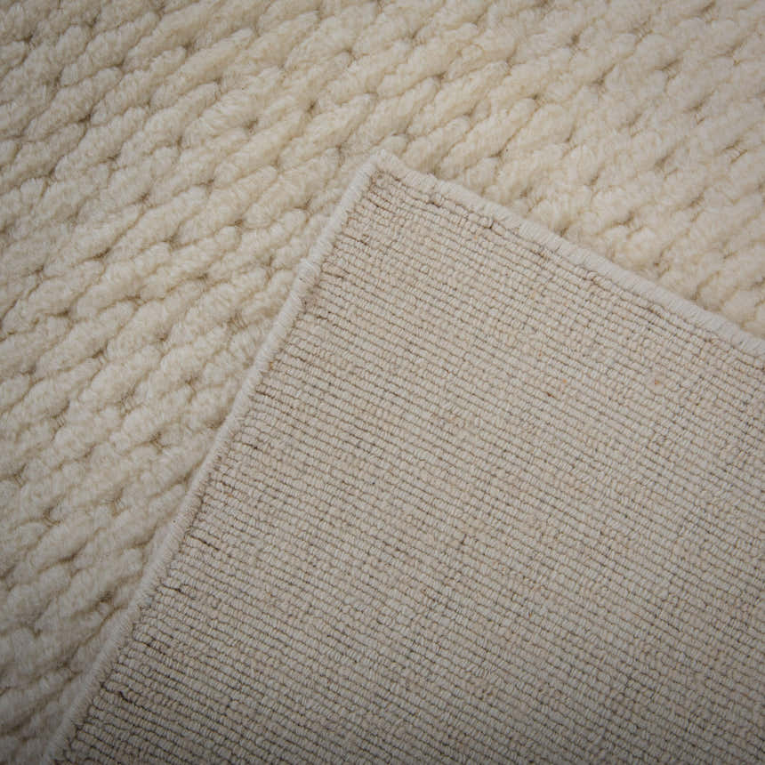 Close up of the ivory Rizzy CLD707 area rug showing its hand loomed texture and 100% wool material. Fold