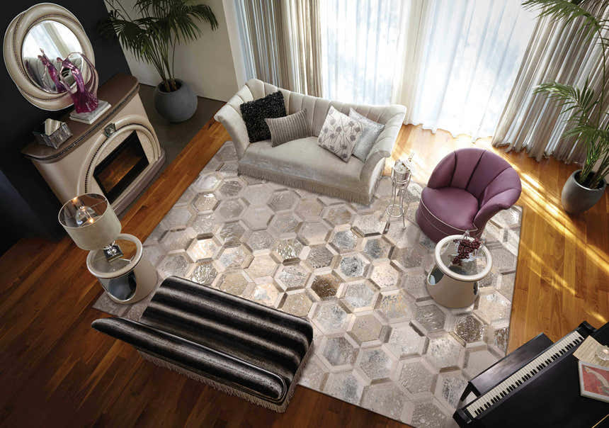 Living room scene with a Michael Amini City Chic silver rug, sofa, piano, and purple chair. Hexagon pattern rug.