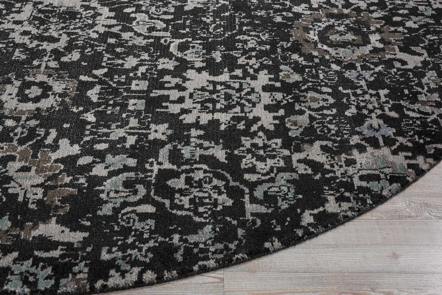 Close up of the Nourison Twilight Onyx Persian rug, showcasing its black, gray, and teal abstract pattern and soft texture.