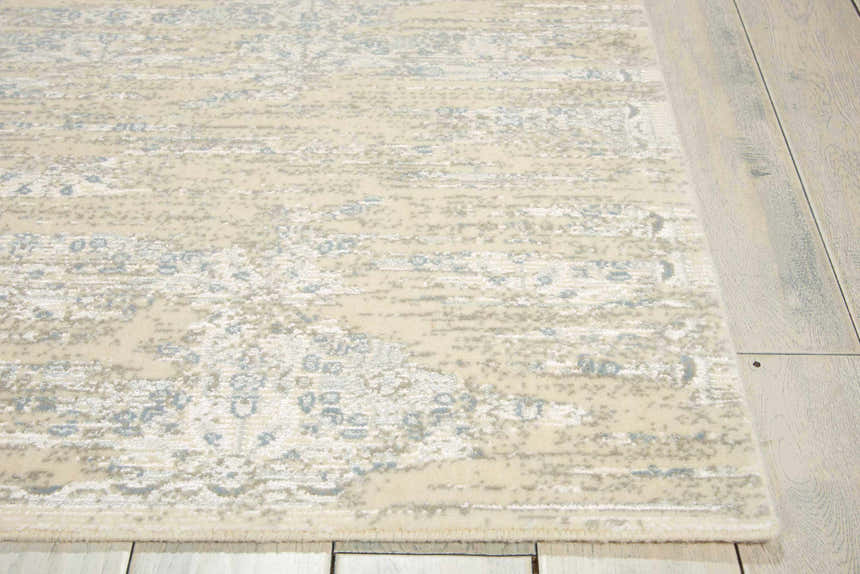 Close-up of the Nourison Luminance Bone Vintage Area Rug, featuring a beige and blue distressed pattern.