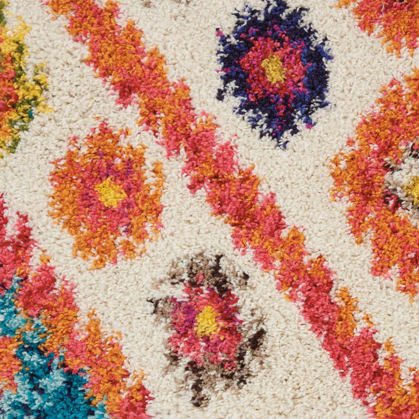 Close-up of the Nourison Nomad Ivory Pink Tribal rug, featuring a floral pattern in pink, orange, blue and brown hues.
