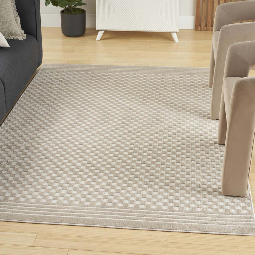 Living room scene with a beige Nourison Care Free rug featuring a modern checkerboard pattern.