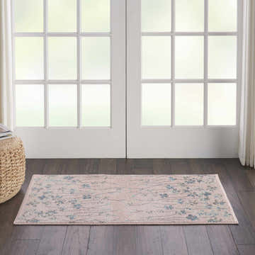 Entryway scene with a Nourison Tranquil Pink rug runner, floral pattern, on dark wood floors in front of white doors.