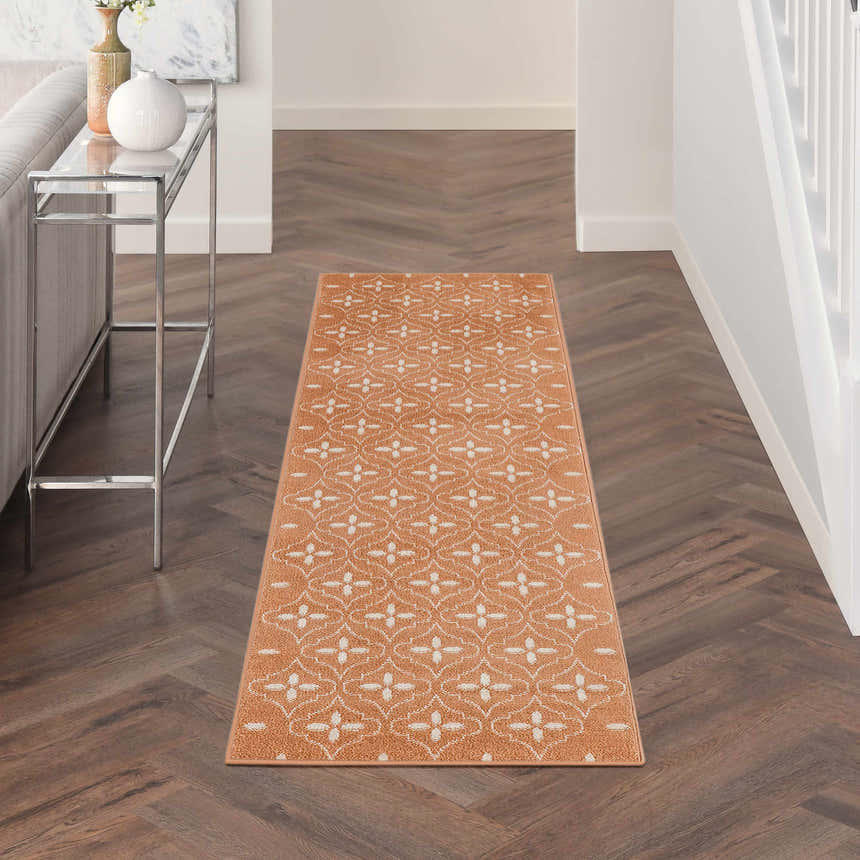 Hallway scene with Nourison Essentials Copper Modern Area Rug on herringbone wood floor.