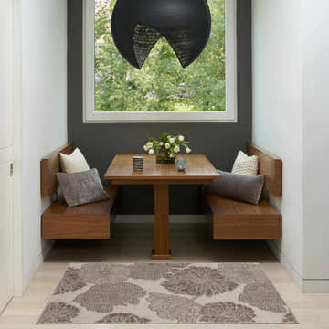Breakfast nook with wood benches and Nourison Garden Oasis Natural Tropical Area Rug featuring a large floral pattern.