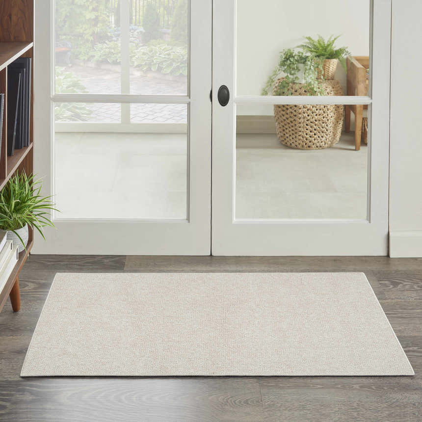 Farmhouse entryway with ivory walls, wood floors, and Nourison Natural Texture Ivory Beige Area Rug.