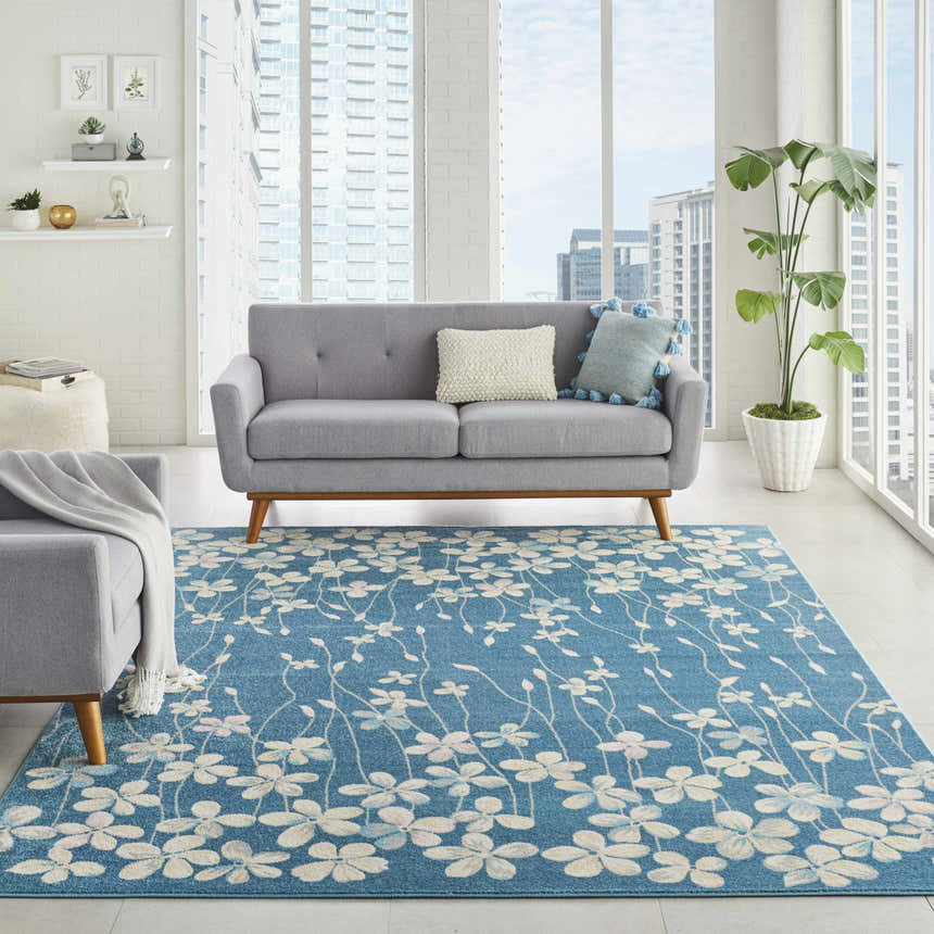 Modern living room with a gray sofa and the aqua Nourison Tranquil rug featuring a floral pattern.