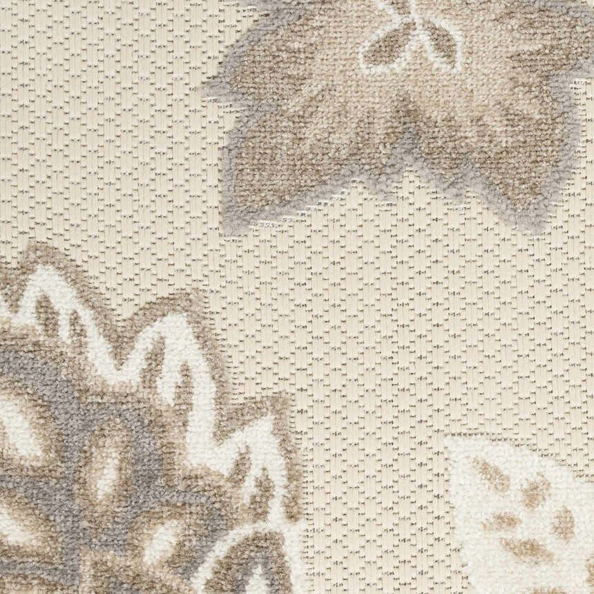 Close-up of the Nourison Aloha Beige Farmhouse Area Rug showing floral pattern and woven texture.
