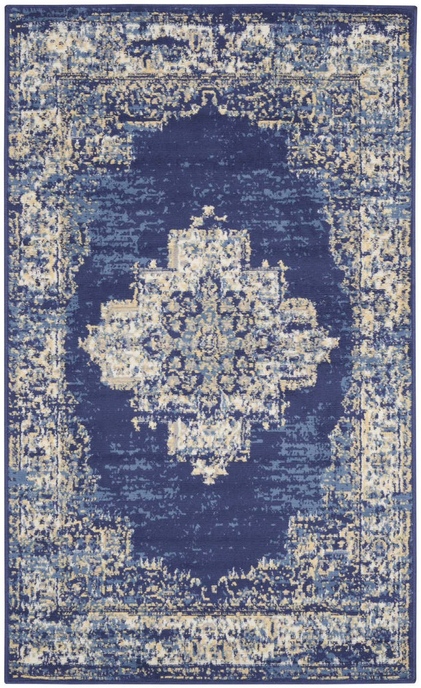 Close-up of Nourison Grafix Navy Blue Vintage Area Rug. Features a distressed, ornate pattern in navy, light blue, and beige tones.