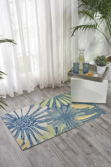 Light-filled room with Nourison Home & Garden Blue Contemporary Area Rug featuring a floral pattern in blue, yellow, and green.