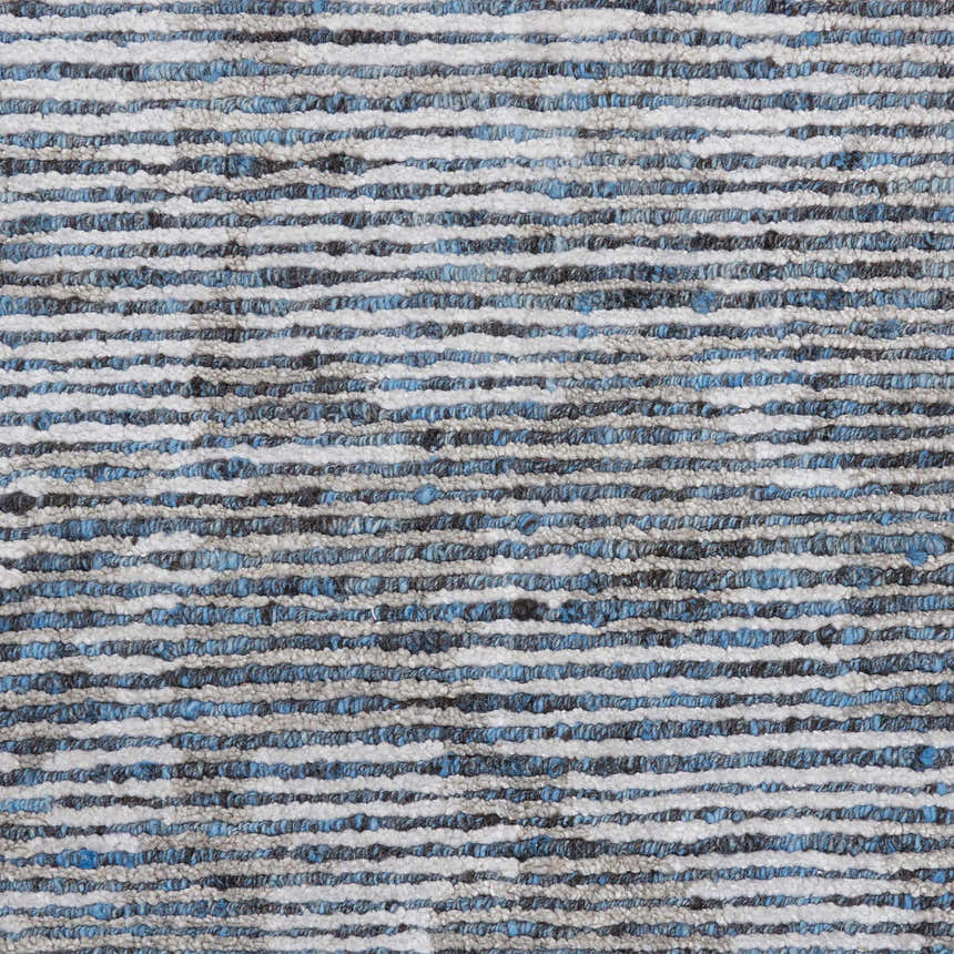Close-up of the Nourison Ellora Slate rug. Features a textured, horizontal stripe pattern in taupe, blue, and gray.