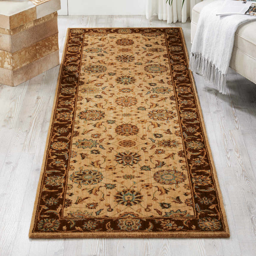 Living room scene with a Nourison Living Treasures Beige Traditional rug, neutral sofa, and wood floors.