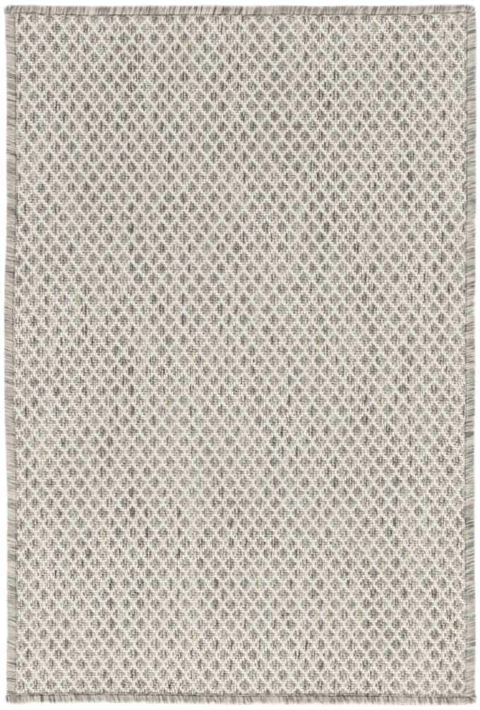 Close-up of the Nourison Courtyard Ivory Silver rug. Features a diamond pattern and fringed edges.
