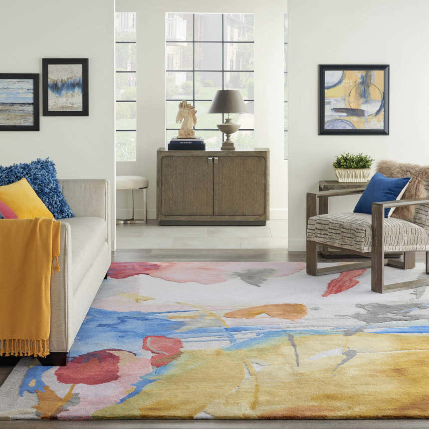 Living room scene with the Nourison Symmetry Multicolor area rug, sofa, and chair.