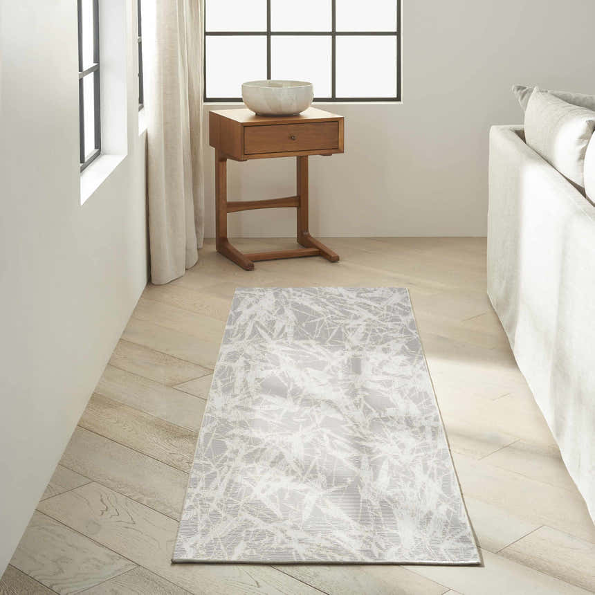 Modern living room with Calvin Klein CK950 Rush Grey Ivory rug, wood floors, side table, and white sofa.