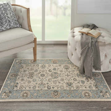 Farmhouse living room scene with Nourison Living Treasures Ivory Aqua rug, chair, and ottoman.