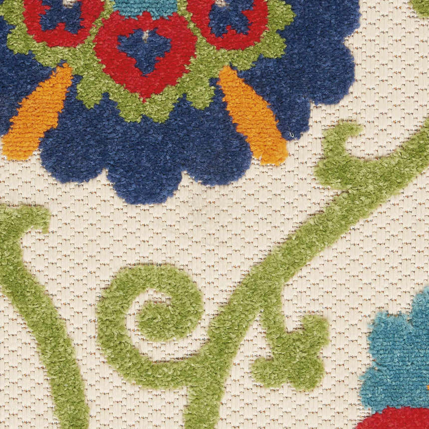 Close up of Nourison Aloha Blue Multicolor rug showing floral design in blue, green, red, and orange on a textured cream background.