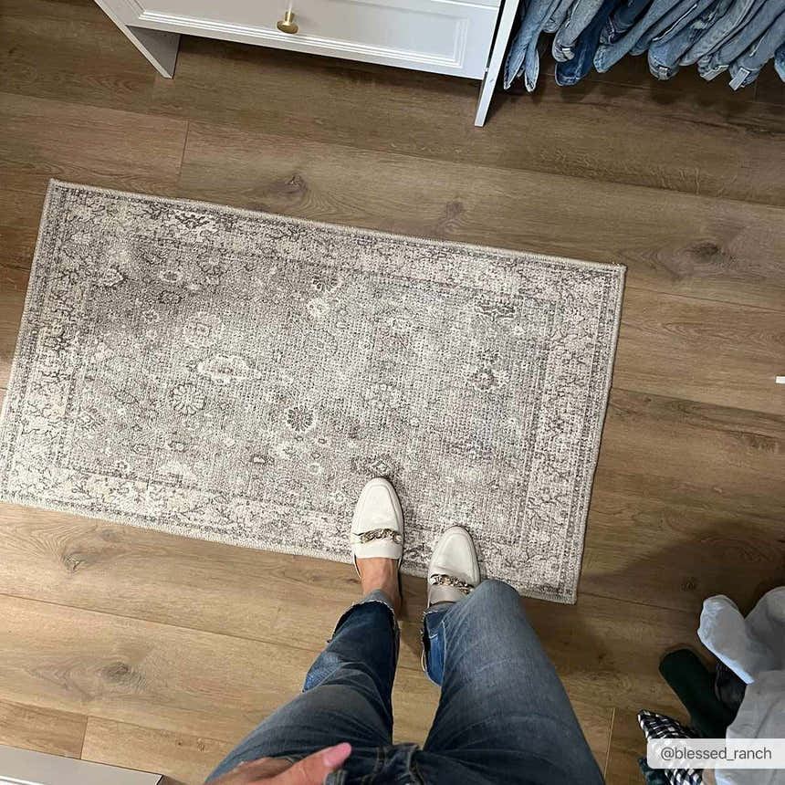 Hallway scene with Davina Becki Owens x LIVABLISS rug. Gray traditional rug on wood floor, white cabinet, and jeans hanging. Roomscene-Rectangle