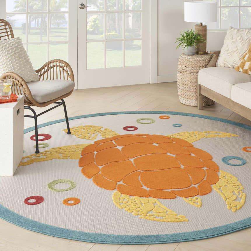 Coastal living room with a Nourison Aloha Teal Multicolor rug featuring a turtle design.