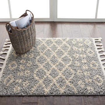 Entryway scene with Nourison Moroccan Shag Silver Tribal rug, wood floors, basket, and bright window.