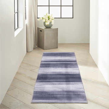 Hallway scene with Calvin Klein Launder Grey Blue rug. Modern, light wood floors, bright natural light.