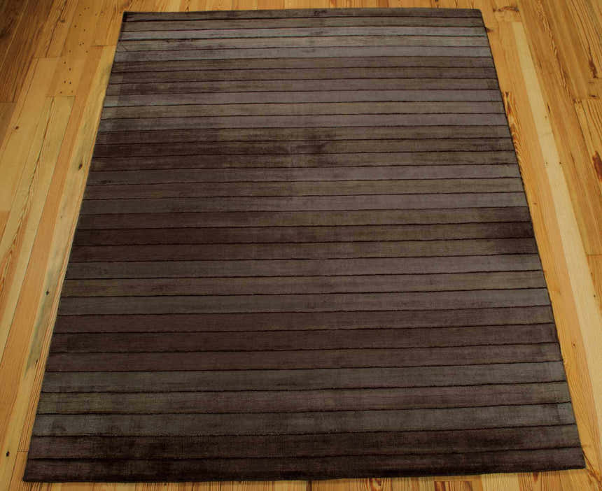 Close-up of the Nourison Aura Chocolate rug. Modern design with horizontal stripes in shades of brown. Luxcelle and cotton texture.