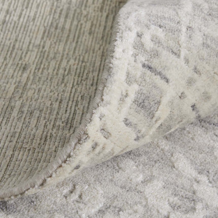 Close-up of the Feizy Eastfield Ivory Area Rug showing the distressed, woven texture and abstract pattern. Fold