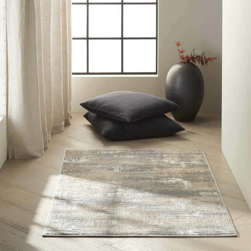 Minimalist room scene with Calvin Klein CK950 Rush Grey Beige modern rug, floor pillows, and black vase by window.