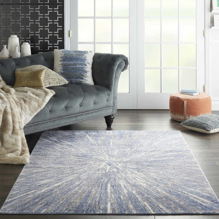 Living room with grey sofa and Nourison Silky Textures Blue Grey rug, a modern focal point.