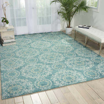 Bright room featuring Nourison Tranquility Aqua rug. Aqua rug has a white floral pattern. White bench and wood floors.
