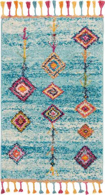 Close-up of Nourison Nomad Aqua Tribal Indoor Area Rug with colorful diamond pattern and playful fringe detail.